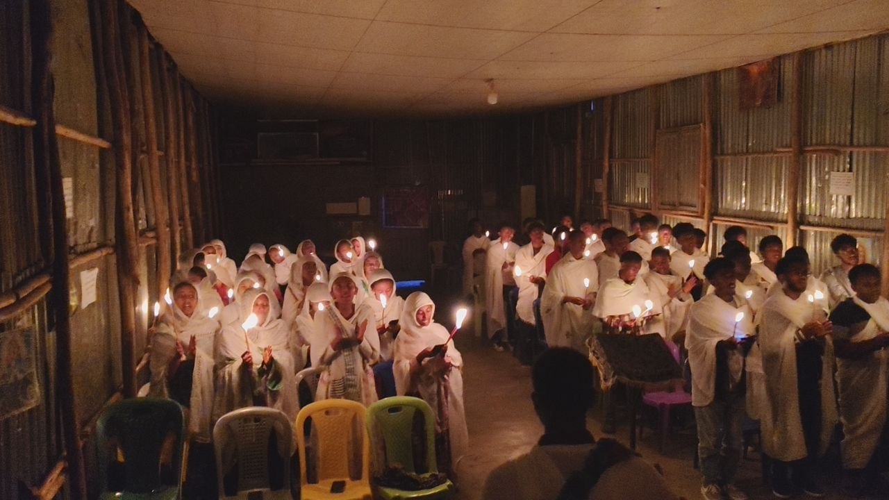 Students of the community holding candles during a night service